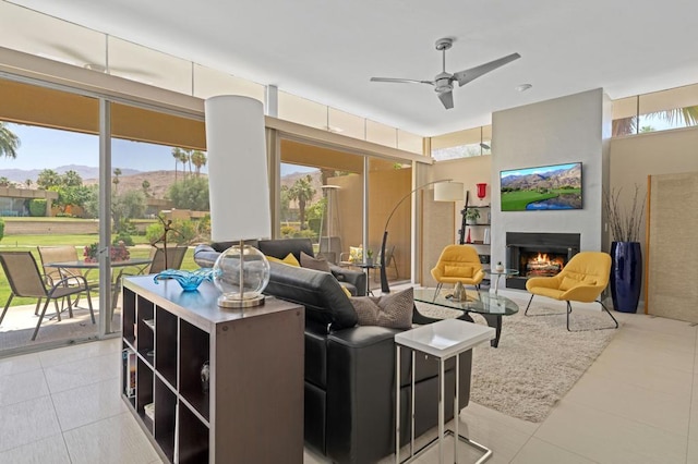 tiled living room with a wealth of natural light, ceiling fan, and a mountain view