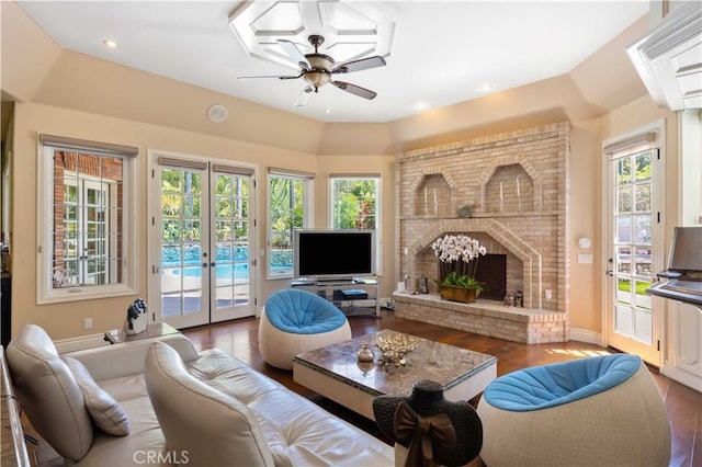 living room featuring a healthy amount of sunlight, wood-type flooring, a fireplace, and french doors