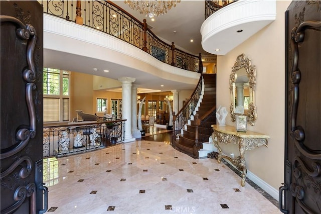 entryway featuring a towering ceiling and ornate columns