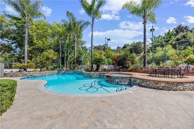 view of swimming pool featuring an in ground hot tub and a patio