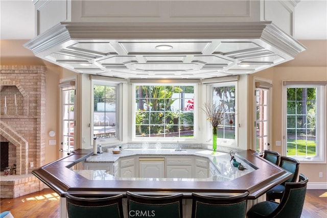 sunroom / solarium with a brick fireplace and coffered ceiling