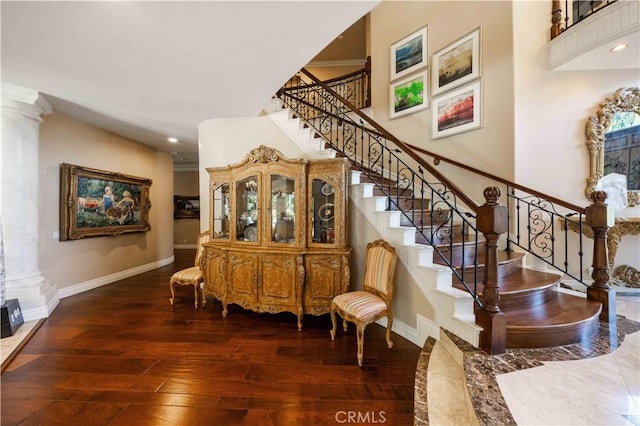 stairway featuring decorative columns and hardwood / wood-style floors