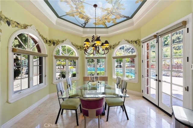 sunroom / solarium with an inviting chandelier, a tray ceiling, and french doors