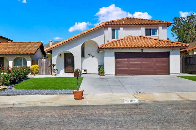 mediterranean / spanish home with a garage and a front lawn