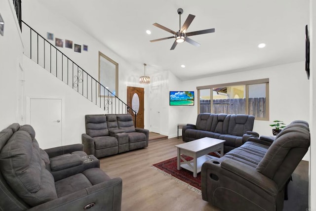 living room with hardwood / wood-style flooring, vaulted ceiling, and ceiling fan