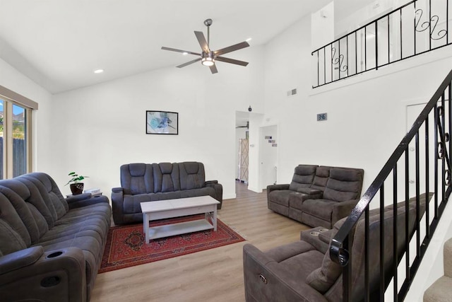 living room with hardwood / wood-style floors, high vaulted ceiling, and ceiling fan