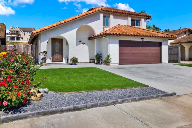 mediterranean / spanish home with a garage and a front yard