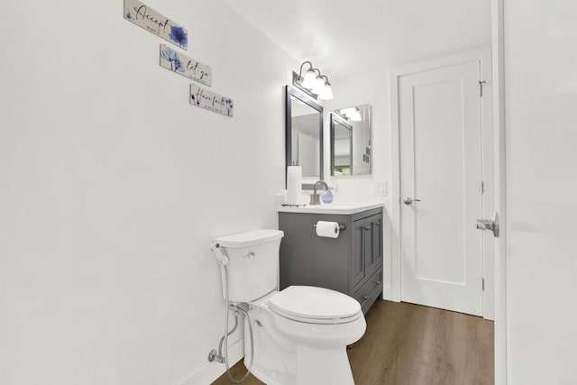 bathroom with wood-type flooring, toilet, and vanity