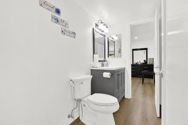 bathroom with vanity, toilet, and hardwood / wood-style floors