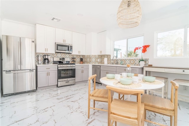 kitchen featuring stainless steel appliances, gray cabinets, backsplash, light tile patterned floors, and crown molding