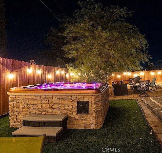 patio at twilight featuring a yard