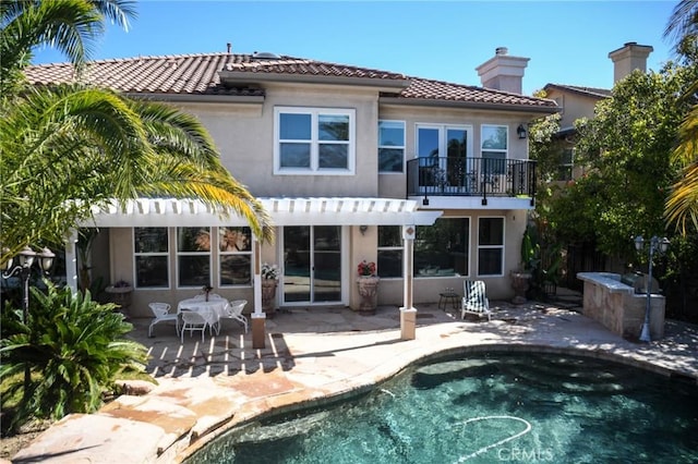 back of property featuring a pergola, a patio area, and a balcony