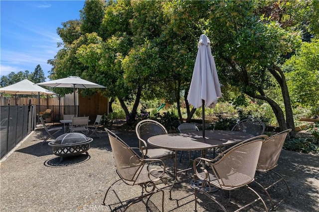 view of patio / terrace featuring an outdoor fire pit, fence, and outdoor dining area