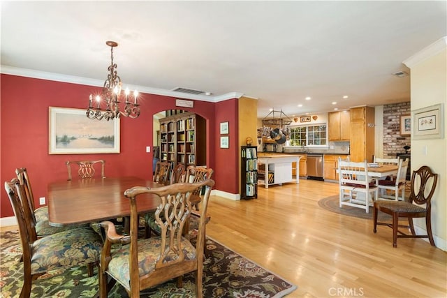 dining space with a notable chandelier, visible vents, ornamental molding, light wood-type flooring, and baseboards