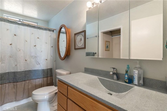 bathroom featuring curtained shower, vanity, and toilet