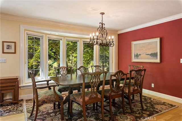 dining room featuring an inviting chandelier, light wood-style flooring, baseboards, and crown molding