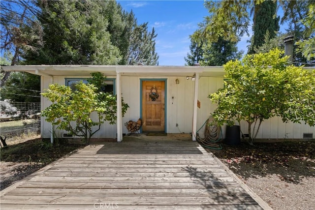 entrance to property featuring crawl space and a wooden deck