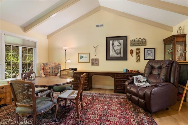 dining space featuring lofted ceiling with beams, wood finished floors, and visible vents