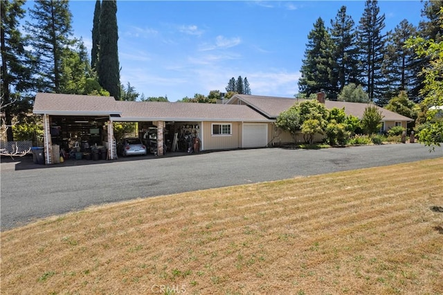 view of front of house with a carport, driveway, and a front lawn