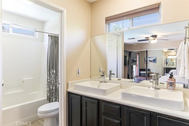 full bathroom with shower / tub combo, vanity, toilet, and a healthy amount of sunlight