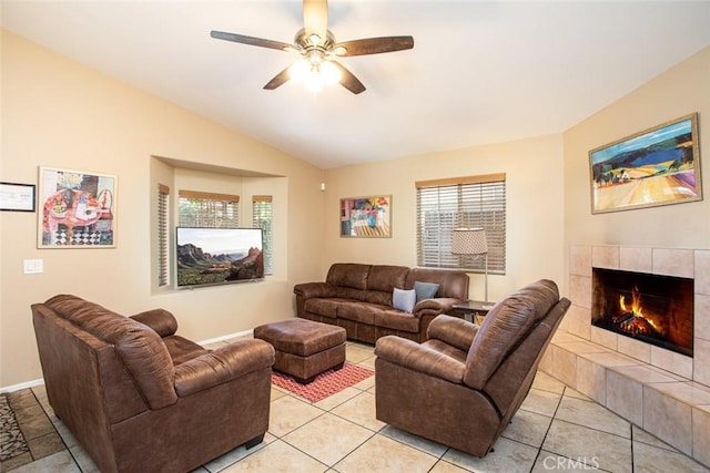 tiled living room featuring a tile fireplace, plenty of natural light, lofted ceiling, and ceiling fan