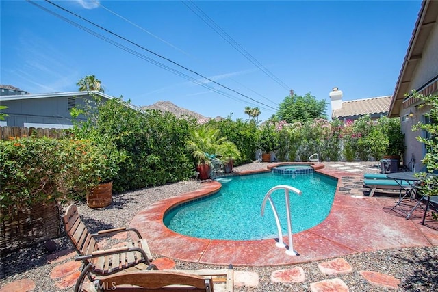 view of pool featuring an in ground hot tub, a mountain view, and a patio area