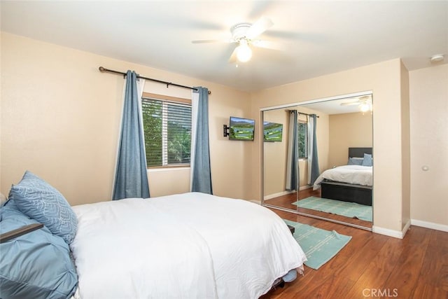 bedroom with ceiling fan, dark wood-type flooring, and a closet