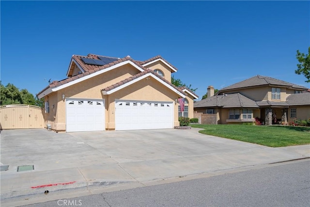 view of front of house with solar panels, a garage, and a front lawn