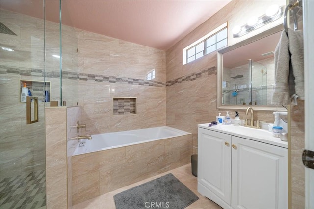 bathroom with tile patterned floors, vanity, plus walk in shower, and tile walls