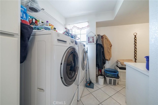 clothes washing area with light tile patterned floors and washer and dryer