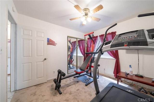 exercise area featuring light carpet and ceiling fan