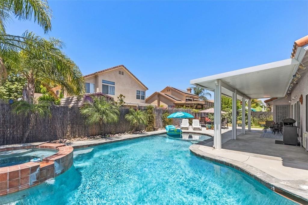 view of swimming pool with an in ground hot tub, a patio, and pool water feature