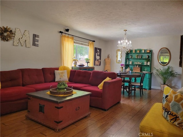 living room featuring wood-type flooring, a chandelier, and a textured ceiling