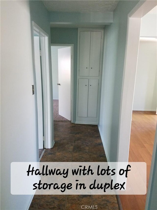 hall with dark tile patterned flooring