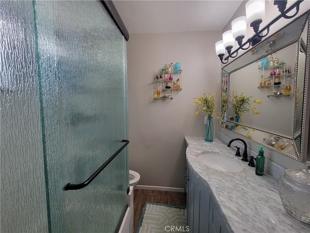 bathroom with hardwood / wood-style flooring, an inviting chandelier, vanity, toilet, and walk in shower