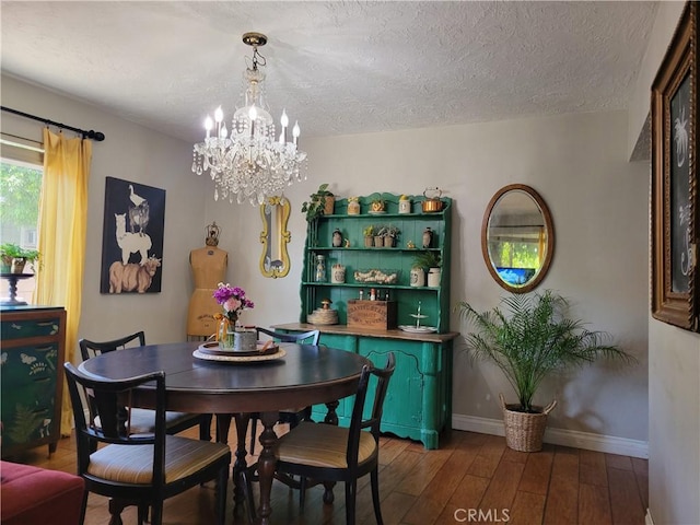 dining area with hardwood / wood-style floors, a textured ceiling, and an inviting chandelier