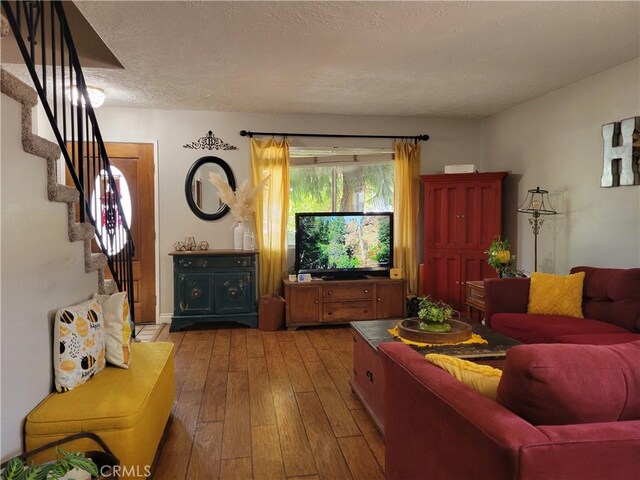 living room with a textured ceiling and hardwood / wood-style flooring