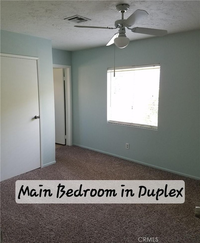 empty room with a textured ceiling, carpet, and ceiling fan