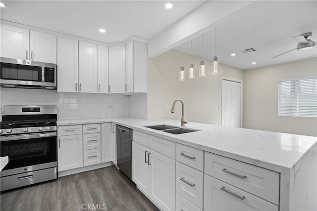 kitchen featuring white cabinetry, kitchen peninsula, sink, and appliances with stainless steel finishes