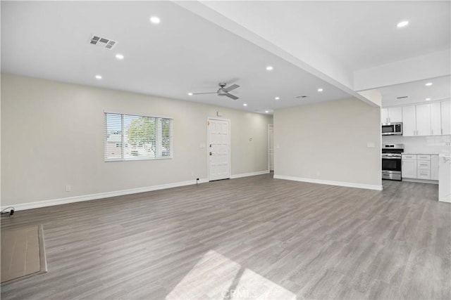 unfurnished living room with ceiling fan and light hardwood / wood-style floors