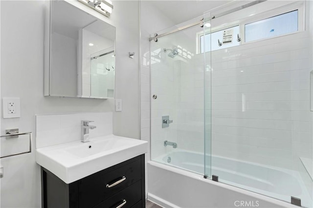 bathroom with decorative backsplash, vanity, and enclosed tub / shower combo