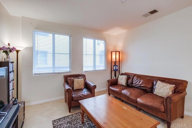 living room with baseboards and visible vents