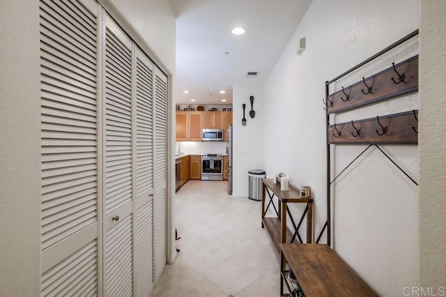 hall featuring light floors, visible vents, and recessed lighting