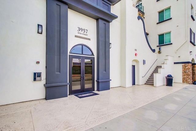 doorway to property featuring french doors and stucco siding