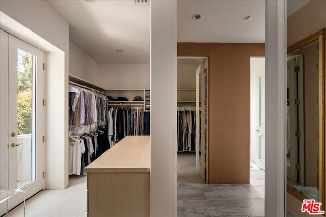 walk in closet featuring light colored carpet