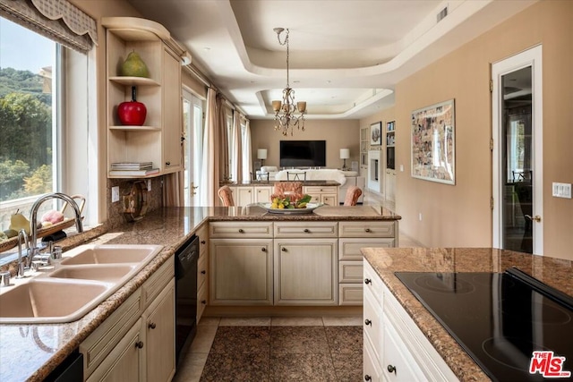 kitchen featuring a notable chandelier, a wealth of natural light, a raised ceiling, and sink