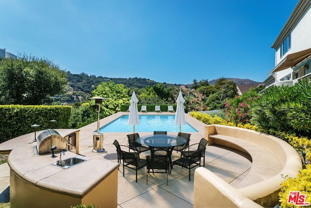 view of swimming pool featuring a mountain view and a patio