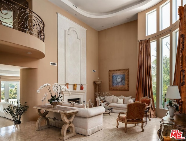 sitting room featuring a high ceiling and a wealth of natural light