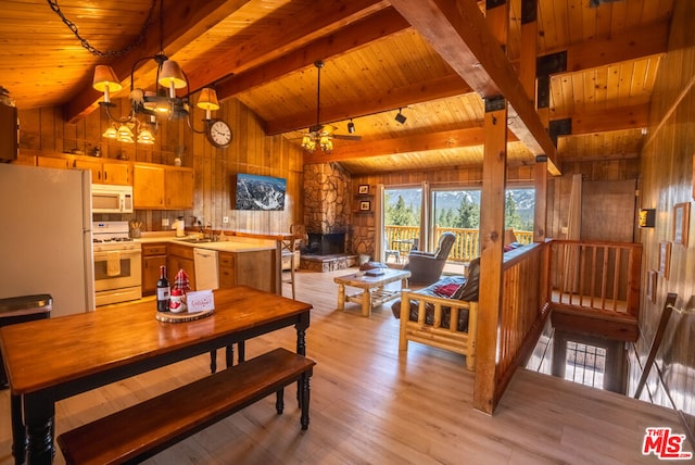 dining area featuring wooden walls, wooden ceiling, lofted ceiling with beams, and light hardwood / wood-style floors