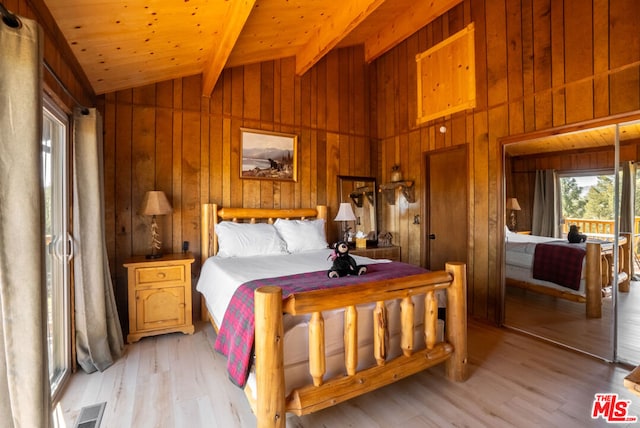 bedroom featuring lofted ceiling with beams, light hardwood / wood-style floors, wood walls, and wooden ceiling